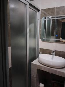 a bathroom with a sink and a mirror at Studio Emeraude - cosy et climatisé - Résidence Saraba Mermoz in Dakar