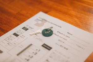 une clé sur un morceau de papier dans l'établissement Tug-B Bar & Hostel, à Otaru