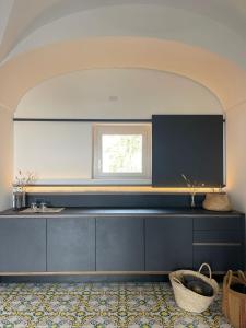 a kitchen with black cabinets and a window at Kirani Resort in Pantelleria