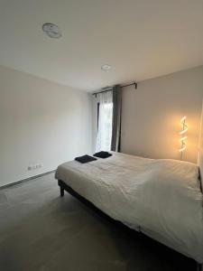 a bedroom with a large white bed with a window at Villa Les Vieux Chênes in Vacqueyras