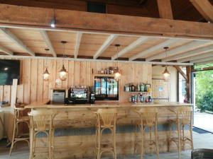 - un grand bar en bois dans un restaurant avec tabourets dans l'établissement Camping Brin d'Amour, à Les Eyzies-de-Tayac
