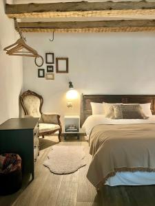 a bedroom with a large bed and a chair at Maison de la montagne - Chambres & Jacuzzi in Arvier