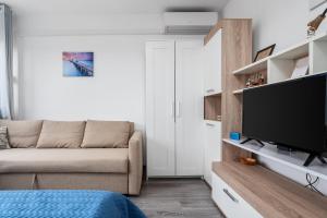 uma sala de estar com um sofá e uma televisão de ecrã plano em Sunshine Split em Split