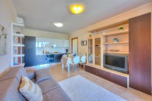 sala de estar con sofá, TV y mesa en Appartamento Zelda With Shared Pool - Happy Rentals en Desenzano del Garda