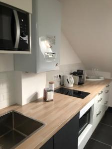 a kitchen with a counter with a sink and a microwave at Jardin des Plantes in Le Mans