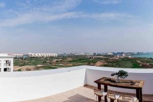 アブダビにあるLuxurious 4 bed apartment on Yas Island, Abu Dhabiの白い壁のテーブルと椅子が備わる客室です。