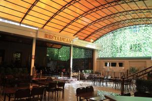 un restaurant avec des tables et des chaises dans un bâtiment dans l'établissement Euro Asia Hotel, à Samarcande