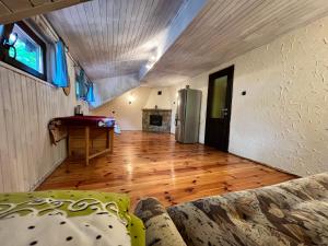 a living room with a couch and a wooden floor at Austeria Przyjezierze in Pojezierze