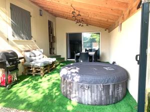 eine Terrasse mit einem großen Fass im Gras in der Unterkunft Studio tout équipé avec jacuzzi in Saint-Didier