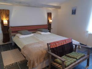 een slaapkamer met een groot bed en een stoel bij BnB Ferme Beauregard Les Pyrénées in Artigat