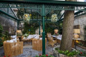 a patio with tables and chairs in a greenhouse at H&ocirc;tel Des Marronniers in Paris