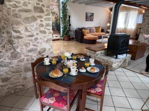 einen Tisch mit Essen darauf im Wohnzimmer in der Unterkunft L'Ermitage de Meyriat in Brénod