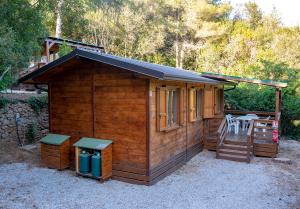 a small wooden cabin with a table and chairs at Elbadoc Camping Village in Cavo