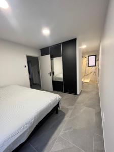 a bedroom with a white bed and a tiled floor at Villa Les Vieux Chênes in Vacqueyras