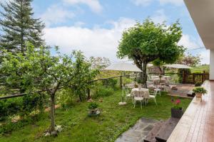 een tuin met een tafel, stoelen en bomen bij Sassi Scritti - Abete Bianco in Montefegatesi
