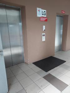 two metal doors in a room with a tile floor at Eryns Homestay seaview in Kuantan