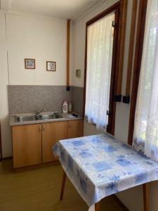 a kitchen with a table and a sink and a window at Chata CONDI in Buchlovice