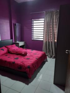 a bedroom with a red bed and a window at Eryns Homestay seaview in Kuantan