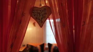 a heart sign hanging between two red curtains at Inselromantik Rügen in Dreschvitz