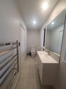 a bathroom with a toilet and two sinks and a mirror at Makuri Bay Hideaway in Purerua