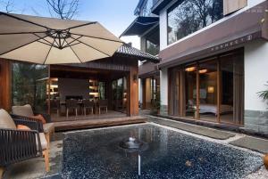 a house with a patio with an umbrella at Formeet Boutique Homestay in Hangzhou