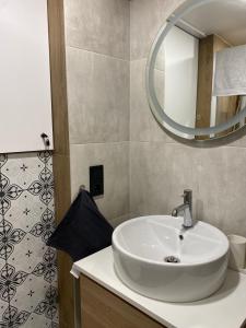 bagno con lavandino bianco e specchio di Soli Lviv a Lviv