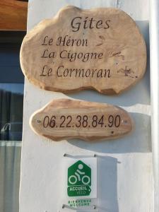 un cartel en una pared con dos tablas de surf de madera en Le Cormoran emplacement idéal, moderne très équipé, en Thury-Harcourt