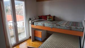 ein kleines Schlafzimmer mit einem Etagenbett und einem Balkon in der Unterkunft Ginî Viñis in Samarína