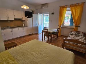 Habitación con cama y cocina con mesa en Apartments La Pergola, en Rovinj