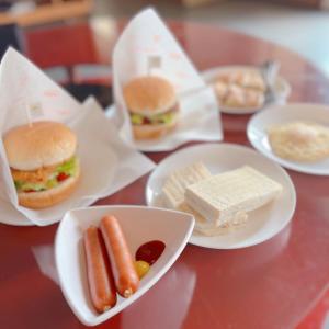 a table topped with plates of hot dogs and sandwiches at Tian Xia Ju Motel in Yilan City