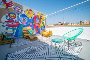 a patio with chairs and a mural on a wall at Live It Madrid Chamberi in Madrid