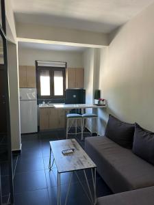 a living room with a couch and a table and a kitchen at Zinozis Beach Apartments in Vourvourou
