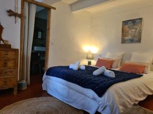una camera da letto con un grande letto con lenzuola e cuscini blu di La Ferme Constantin a Fayence