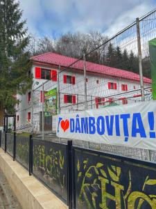 a banner on a fence in front of a building at Hotel Gâlma in Moroeni