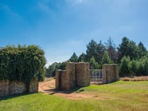 an old stone wall with a gate in a field at Kinloch Lodge in Dullstroom