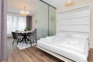 a bedroom with a bed and a table with chairs at Stunning Apartment with Parking in Gdansk Lower Town by Renters in Gdańsk