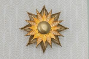 a gold sun decoration on a wall at Stunning Apartment with Parking in Gdansk Lower Town by Renters in Gdańsk