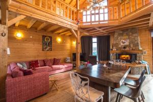 uma sala de estar com uma mesa e uma lareira em Large Luxury Chalet in Raduil, nr Borovets - hot tub, views, Wi-Fi em Raduil