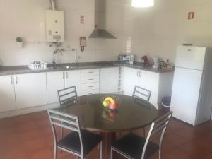 a kitchen with a table and chairs and a refrigerator at Casa do Olival in Peso da Régua