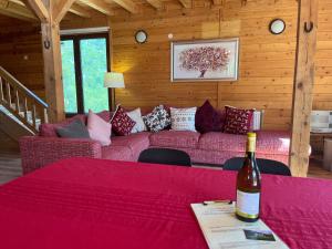 een woonkamer met een bank en een fles wijn bij Large Luxury Chalet in Raduil, nr Borovets - hot tub, views, Wi-Fi in Raduil