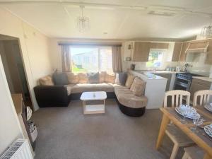 a living room with a couch and a kitchen at Seaside Holiday Home St. Osyth, Essex 2 Bathroom, 6 Berth with Country Views in Saint Osyth