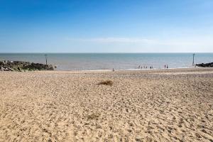 a beach with a group of people in the ocean at Seaside Holiday Home St. Osyth, Essex 2 Bathroom, 6 Berth with Country Views in Saint Osyth