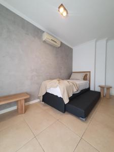 a bedroom with a bed and a bench in it at Premium appart LOCADOR Nueva Cordoba14C in Cordoba