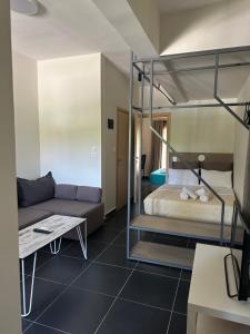 a bedroom with a bunk bed and a couch at Zinozis Beach Apartments in Vourvourou