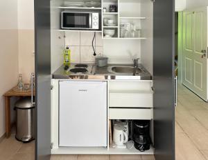 eine kleine Küche mit einer Spüle und einer Mikrowelle in der Unterkunft Himmelreich Rügen in Zirkow