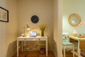 a room with a desk with a laptop and a clock at Meraki down town apartment in Ágios Rókkos