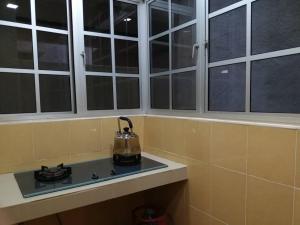 a kitchen with windows and a tea kettle on a stove at Crown imperial in Brinchang