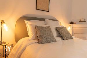a white bed with two pillows on top of it at Les pierres blanches : T2 - Hypercentre Angoulême in Angoulême +6 photos