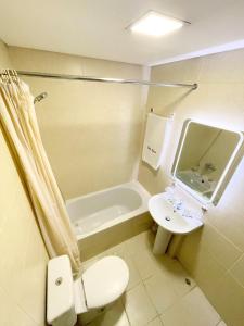 a bathroom with a toilet and a sink and a tub at Bella Rosa Hotel in Beirut