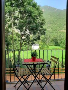 a table and chairs on a balcony with a view at Les LLaus in Ribera de Cardós